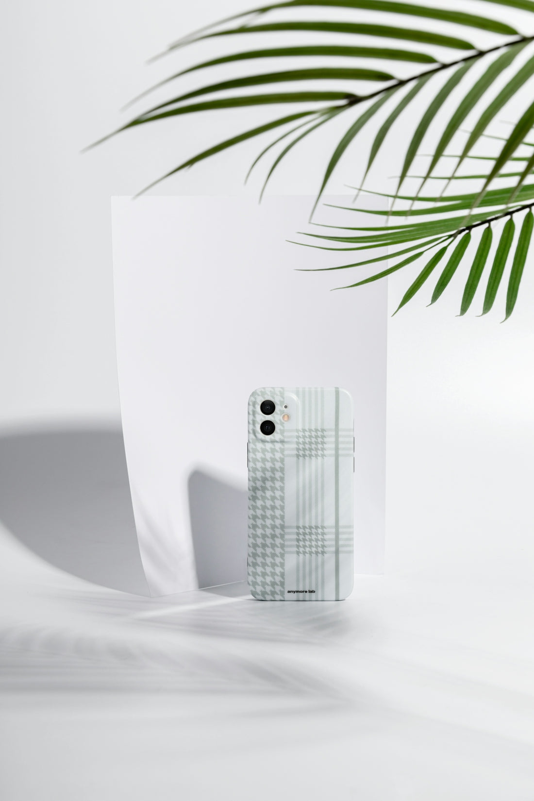 a cell phone sitting next to a palm leaf